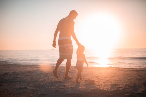 Father walking with his child on the beach